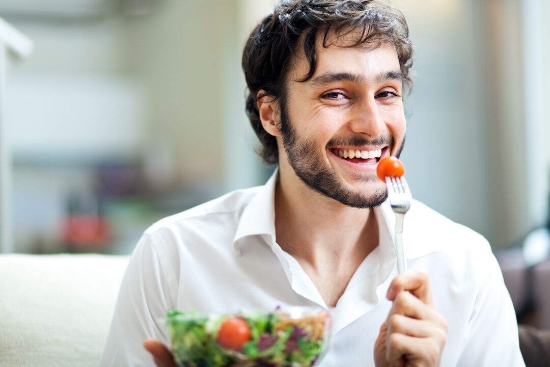 El hombre come verduras para potenciar