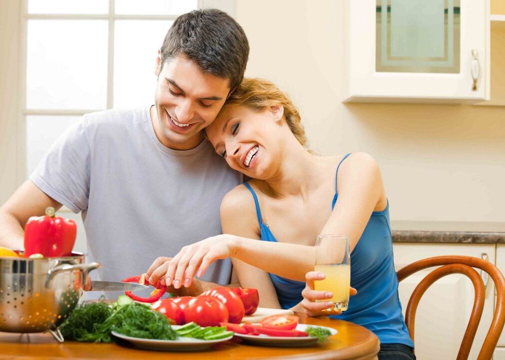 mujer y hombre preparan verduras para aumentar la potencia